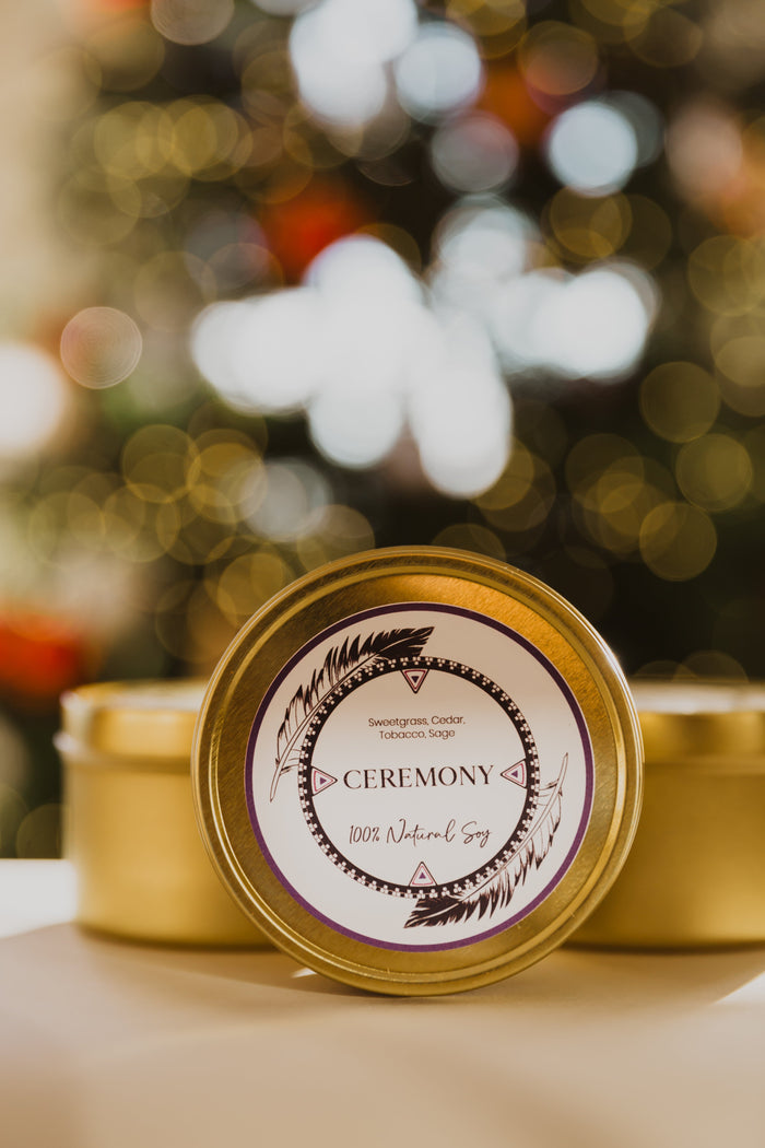 The 8oz Travel Tin in Ceremony in front of 2 travel tins by LODGE Soy Candles and a blurred Christmas tree..