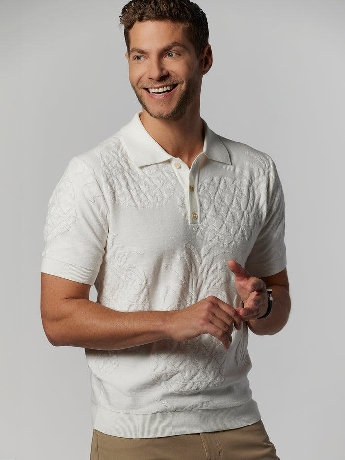 White sweater polo, solid color, with beige pants, front view.