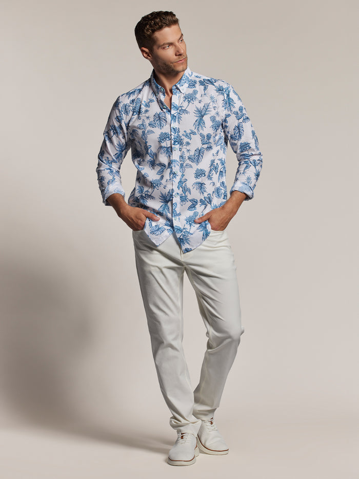 Image 1: White floral-print long-sleeve shirt, white pants & shoes, front view. Image 2: Same outfit, hands in pockets.