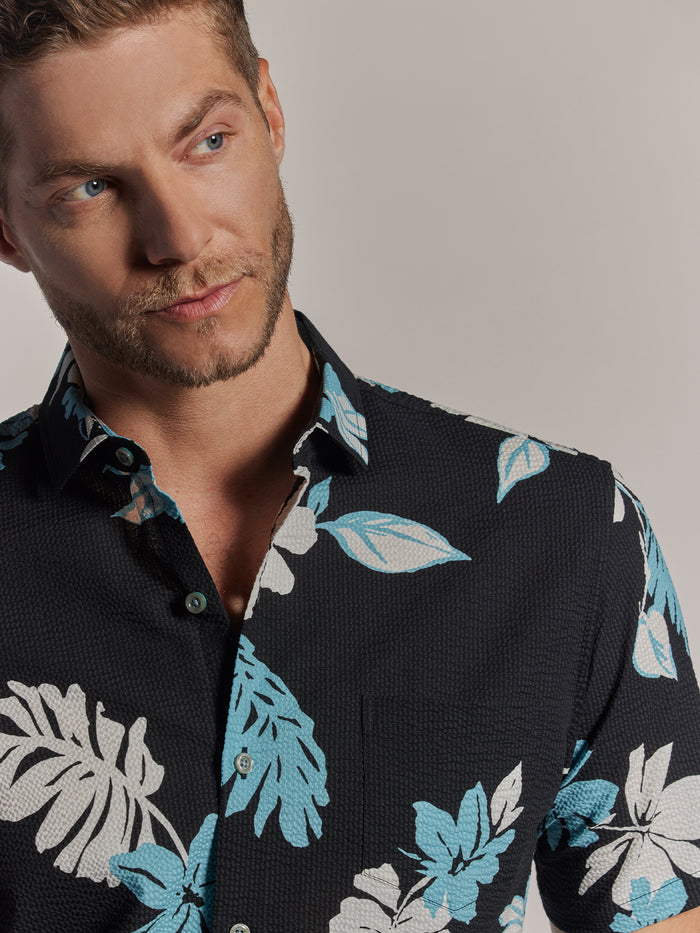 black and white leaf-print short-sleeve shirt, side view on model.