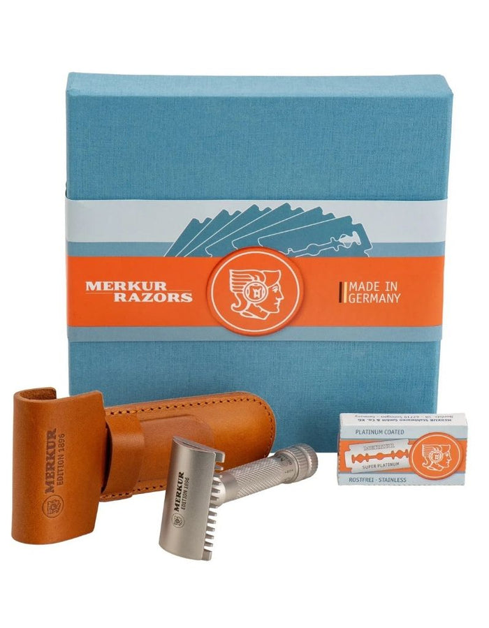 Merkur stainless steel safety razor with textured handle, included leather case, and packaging, designed for close, comfortable shaves.