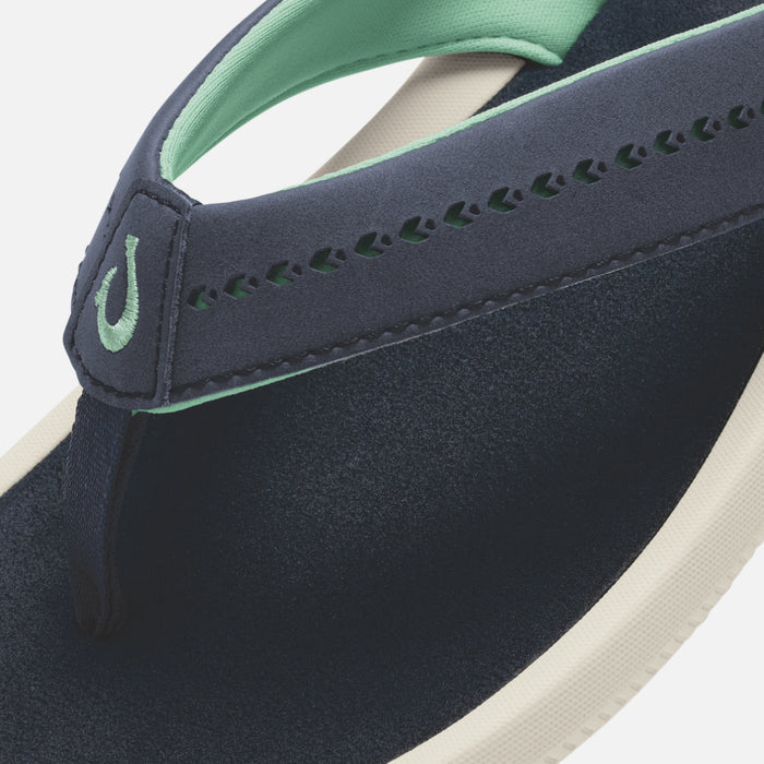 Dark navy flip-flop with mint green strap, cream sole, and decorative stitching detail.
