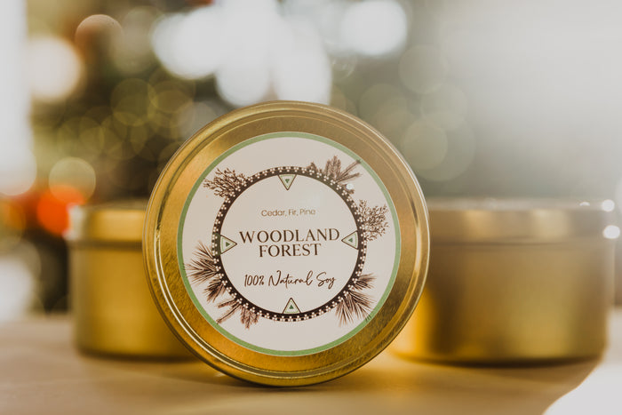 The 8oz Woodland Forest tins in front of two LODGE Soy Candle travel tins and a dreamy Christmas background.